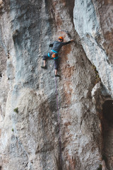 Fototapeta premium A man in helmet climbs the rock.