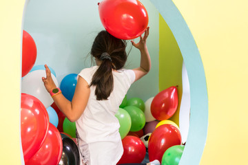 Kleine Mädchen im Kindergarten spielen mit Luftballons