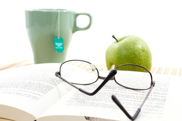 Brille, Buch und ein Heißgetränk