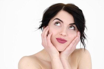 Fototapeta premium emotion face. happy smiling romantic woman holding head in hands and looking up. young beautiful brunette girl portrait on white background.