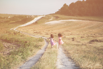 two happy girls walking in countryside on trail in sunny summer day lifestyle