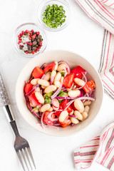 Salad with white beans, tomatoes, red onions, green coriander, parsley, delicious diet lunch