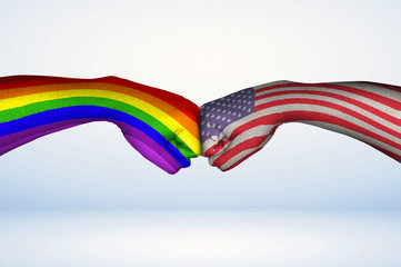 Fist bump of American and Pride Flags.
Two hands with painted flags of USA and the Pride Rainbow Flag fist bumping as a symbol of acceptance. 

