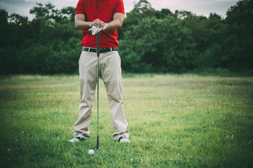Fototapeta premium Golf club and ball on grass,Golfer play golf in a country club,Thailand people,The golf training before the competition.