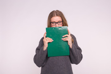 Portrait of young student woman with paper clip in hands on white background