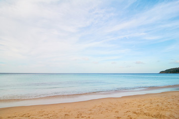 Sand beach with blue water and sky.