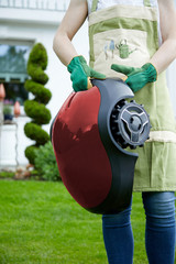 Woman holding an autonomous rechargeable mower