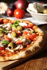 Homemade Greek Style Pizza / with tomatoes, red onions, feta cheese, olives, garlic and basil leaves