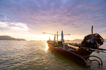 Travel in Thailand.  Colorful landscape with sea beach, traditional longtail boat over beautiful sunset background.