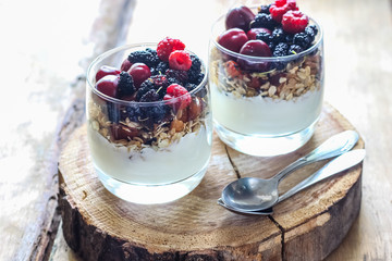 Granola with yogurt and berries in a glass. Delicious healthy American food for breakfast. Traditional US snack. Selective focus
