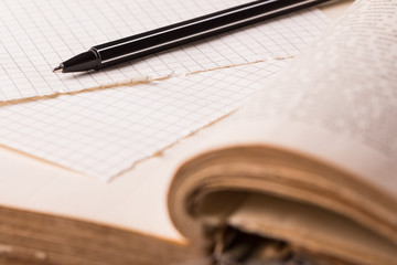 Pen and pages in  cage lie on old wise book.  Concept of education.
