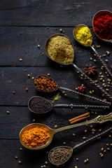 Indian spices selection over dark wooden table. Food or spicy cooking concept, Healthy eating Background.