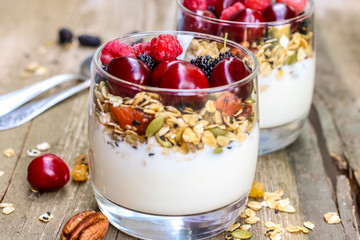 Granola with yogurt and berries in a glass. Delicious healthy American food for breakfast. Traditional US snack. Selective focus