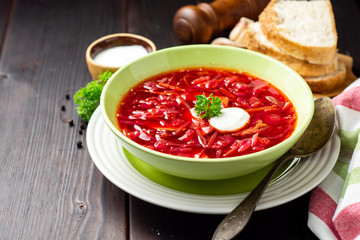Borsch - traditional Ukrainian and Russian beetroot soup on dark wooden background