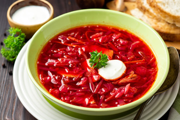 Borsch - traditional Ukrainian and Russian beetroot soup on dark wooden background