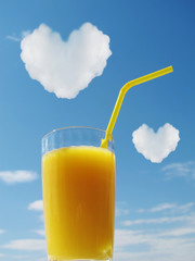 A glass with yellow juice against the blue sky. 2 clouds in the form of hearts. A metaphor for rest and love.