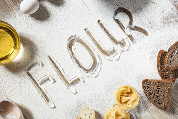 Sliced homemade wheat bread with wheat flour on a wooden background. Ton view