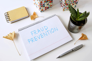fraud prevention written in a notebook on white table
