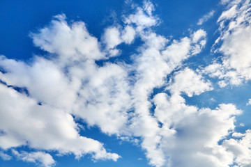 Naklejka na ściany i meble white fluffy soaring clouds on a blue sky background