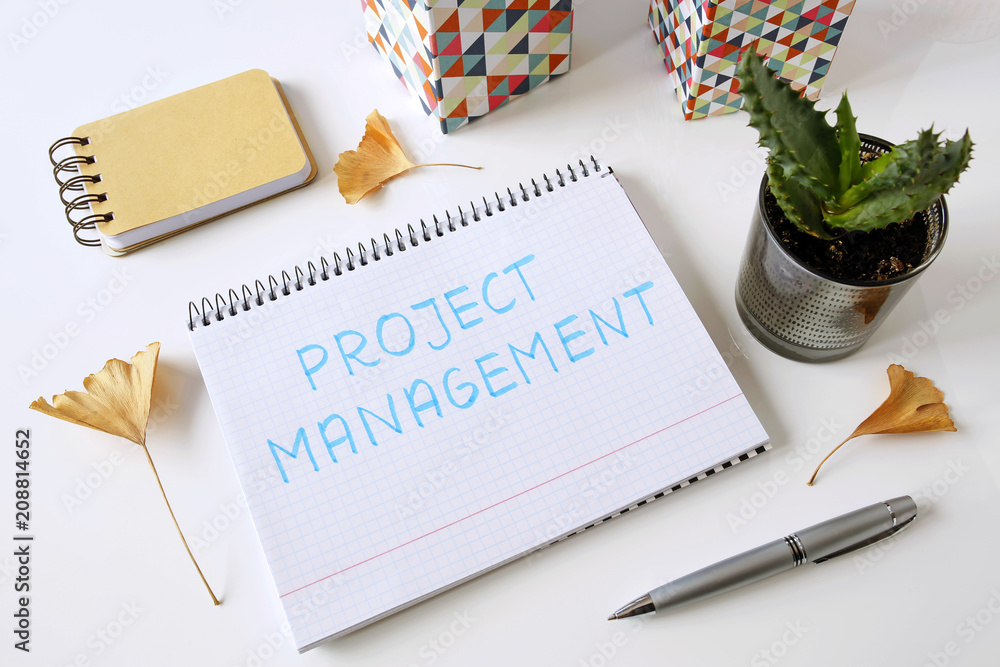 Poster project management written in a notebook on white table