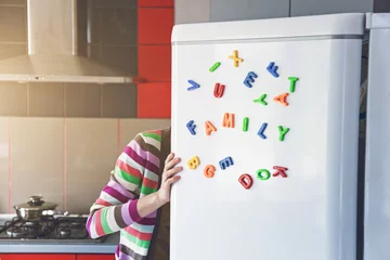 Foto op Aluminium Woman looking in open fridge with Family letters on door. Cooking for children and husband concept © Ivan Kruk