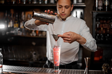 Bartender making a fresh and cold strawberry mojito summer cocktail