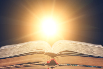 The open book lies on the table and the sun shines from it. Library, the concept of education. Empty place for text.