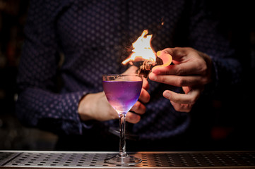 Bartender making a strong fresh purple summer cocktail with a smoke note