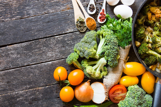 fresh broccoli and orange tomatoes, cooked broccoli with mushrooms, carrots and potatoes. organic and vegan food kitchen 