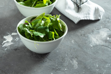 Fresh green mixed salad in a bowl on a dark table. Healthy concept.
