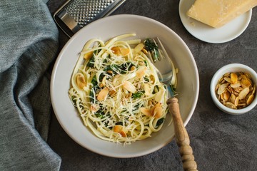Homemade pasta with spinach, parmesan cheesse and almonds