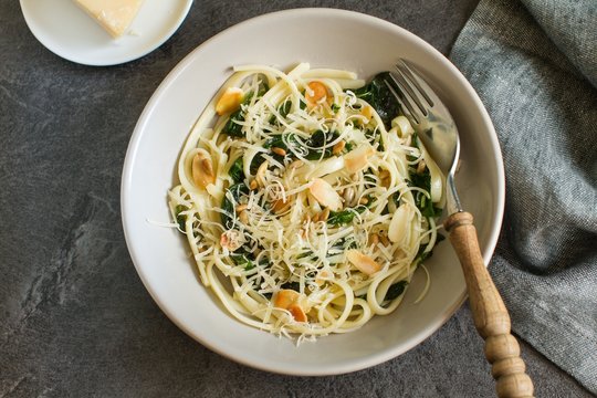 Homemade pasta with spinach, parmesan cheesse and almonds