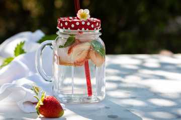 Glass jar of iced detox water with strawberry, mint. Summer concept.