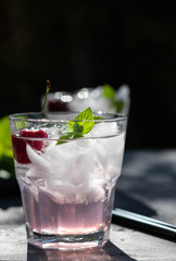 Summer berry lemonade with cherry, ice and mint in glass. Summer concept.