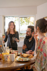 bunch of friends gathered around a table for breakfast