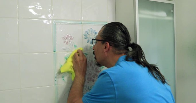 Obsessive man cleaning bathroom