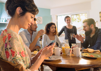Group of multi-ethnic friends gathered around a table for breakfast