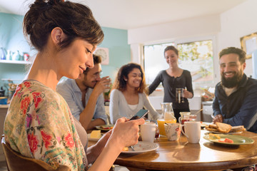 Group of multi-ethnic friends gathered around a table for breakfast