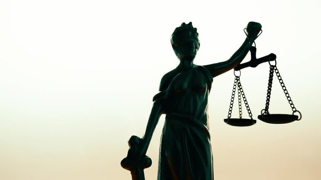 Statue of lady Justice or Justitia with scale on bright background, conceptual footage