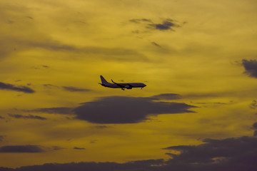 Fototapeta na wymiar Silhouette of an airplane during landing on sunset background