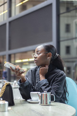 Black girl having a cup of tea on a modern terrace