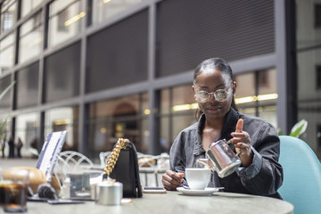 Black girl having a cup of tea on a modern terrace