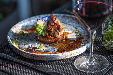 Grilled steak meat with potato gratin and glass of red wine