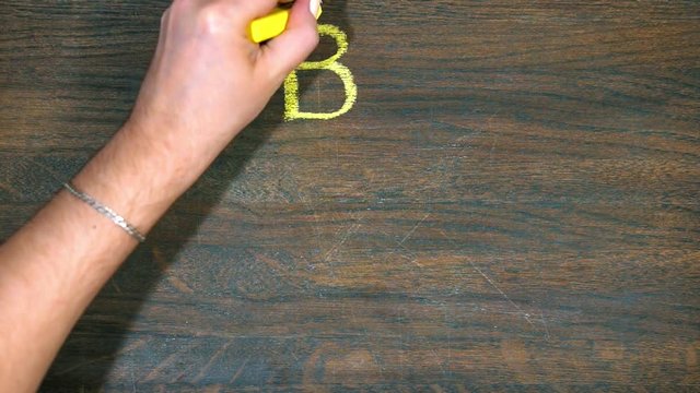Closeup of hand draws on a wooden board. The fall of the bitcoin.