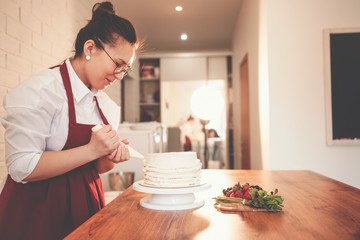 Chef smears cake with cream