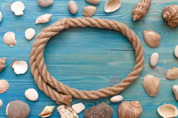 Summer vacation background with copy space. Sea rope border frame with scattered around various seashells and pebbles.