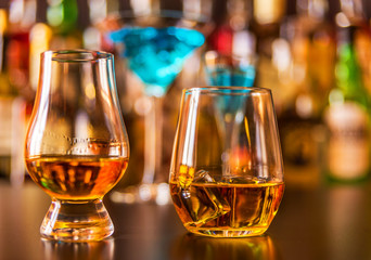 Scottish whisky in a glass with ice cubes, golden color whiskey