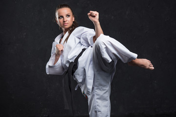  A girl in a white kimono with a black belt on a dark background