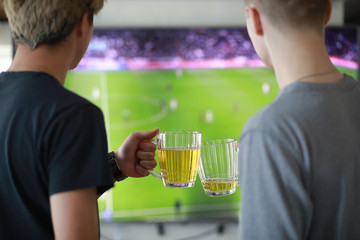 Football fans watch the match and drink beer