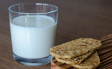 Glass of milk with wholegrain cookies on wooden desk. side view. close-up